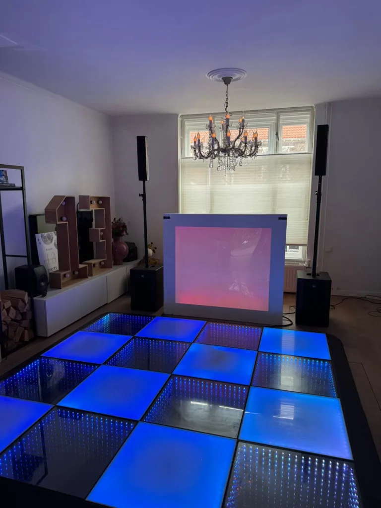 Blauw verlichte discovloer in een huiskamer, met dj-booth, speakers en lichtletters