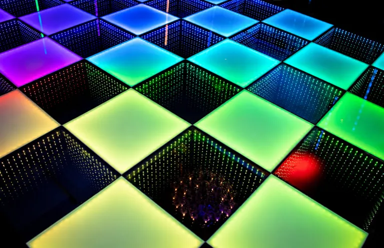 Close-up van de tegels van een LED-dansvloer in blauw, groen, paars en geel