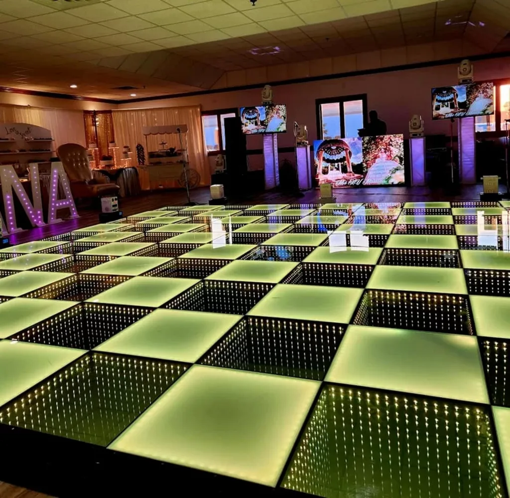 Groen verlichte LED-dansvloer in een zaal, waarin de spiegeltegels het licht in de diepte herhalen